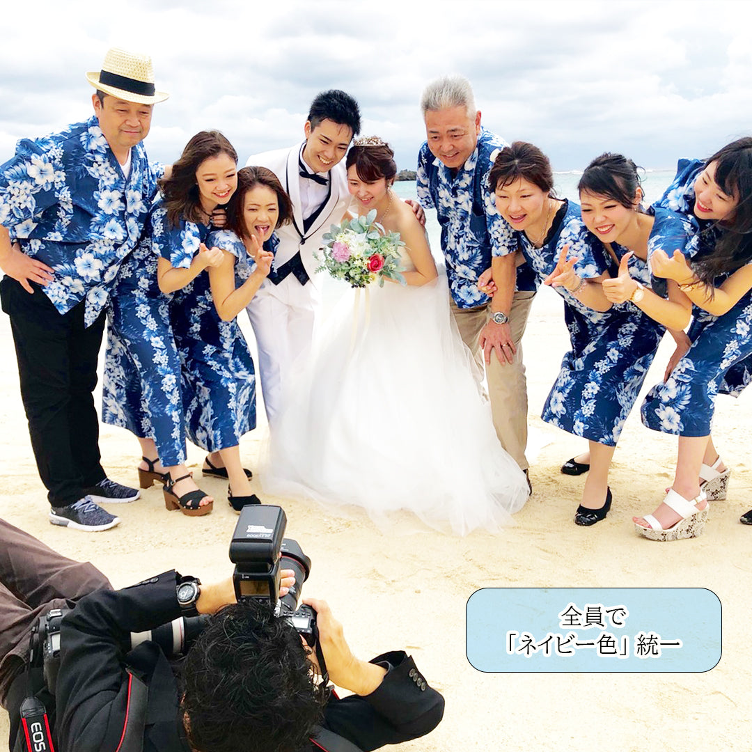 沖縄やハワイのリゾート婚で人気｜ネイビーのアロハシャツとムームーで統一したゲスト衣装が映える結婚式の集合写真

